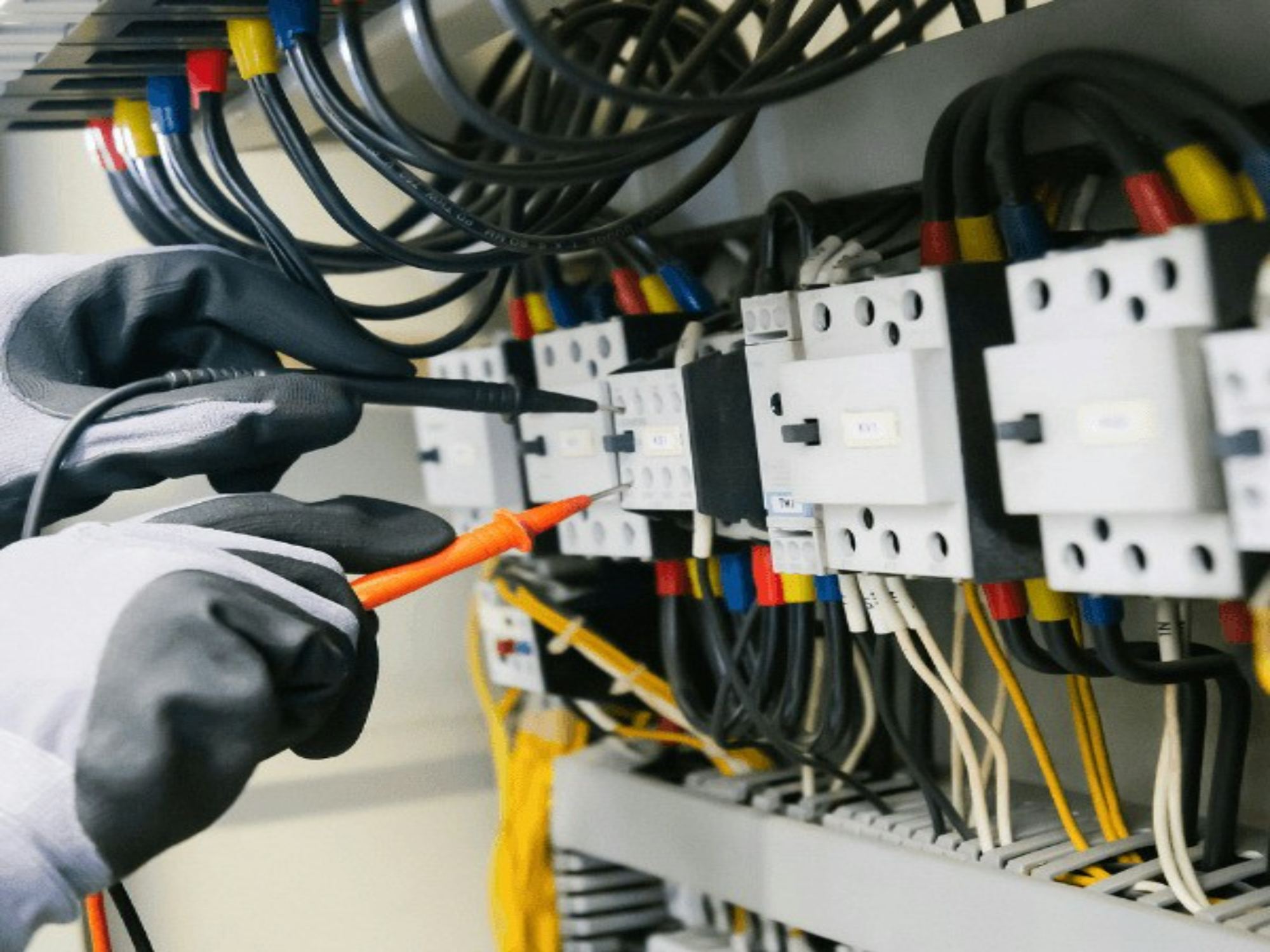 An electrician testing a consumer unit with a multimeter